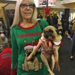 Woman holds her tongue out pug at the Pugalug Pug Claus Christmas Party